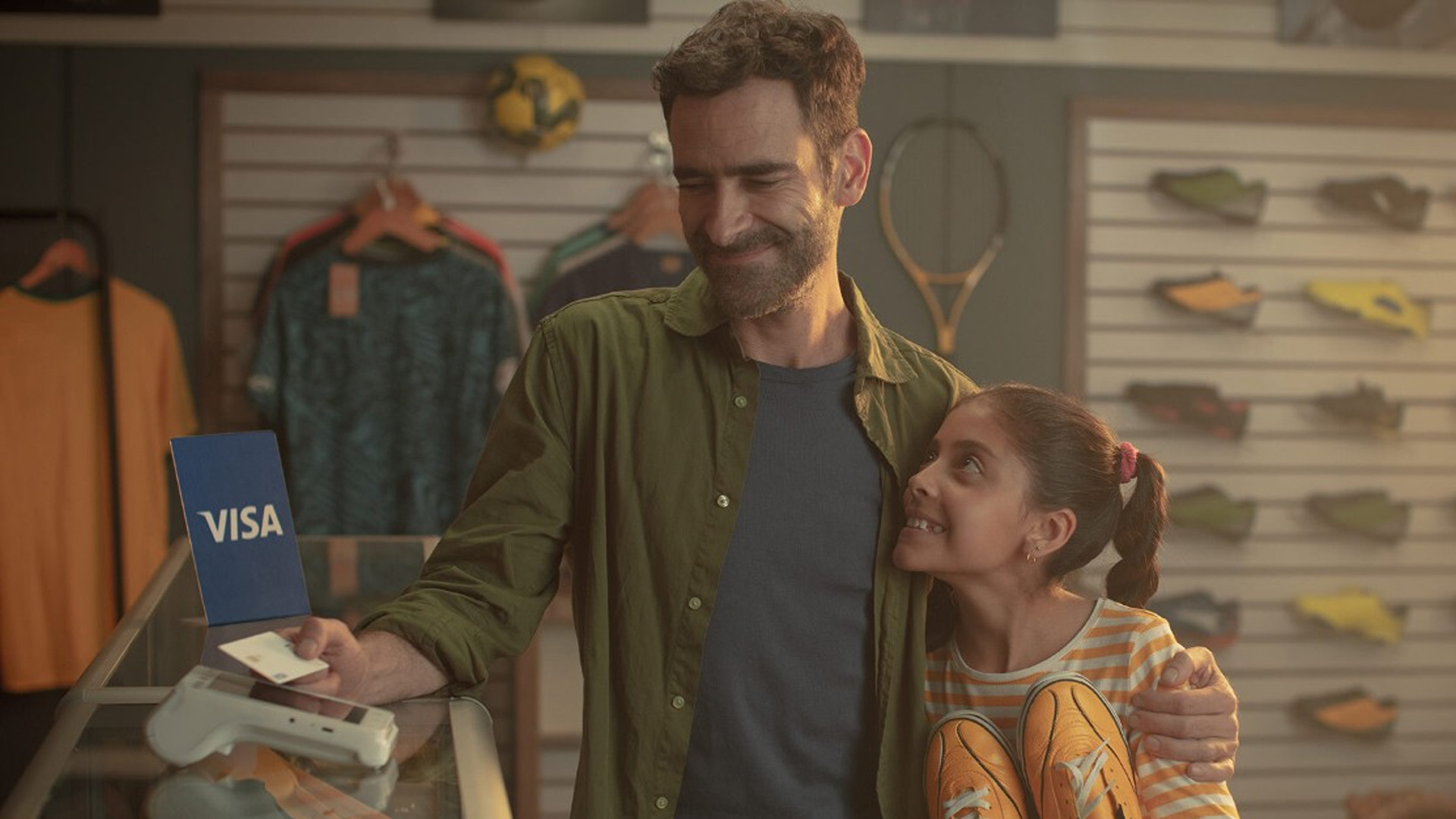 Padre e hija pagando sin contacto con Visa